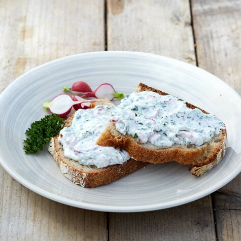 Kruidige plattekaas op een snee CRU-brood.